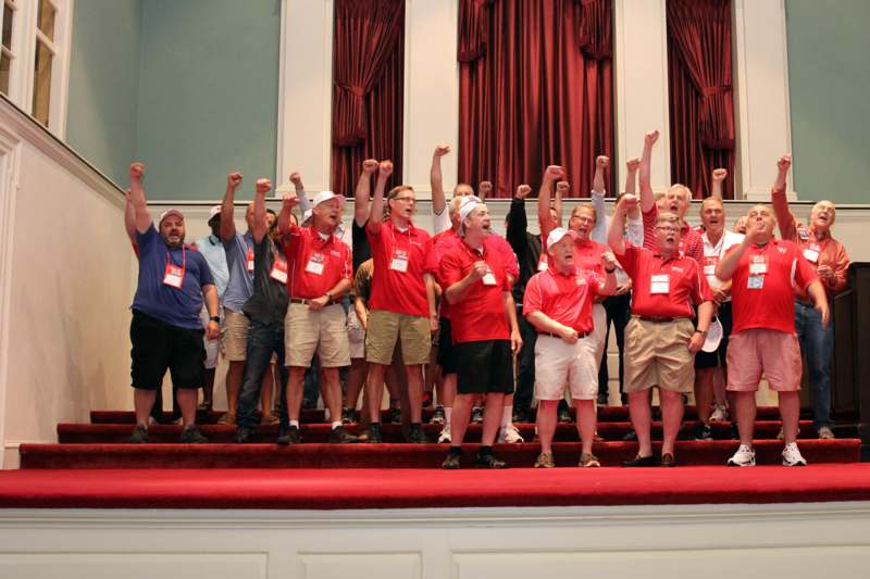 a group of people standing on stairs with their hands raised