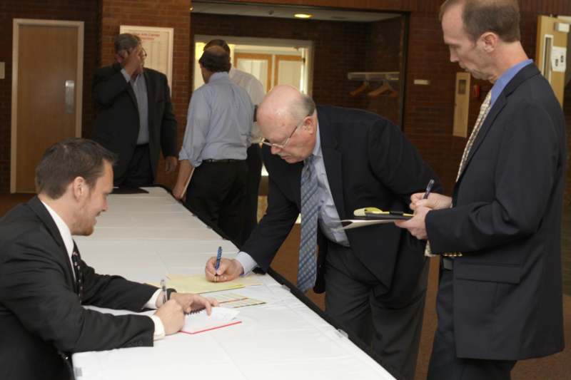 a group of men in suits signing papers