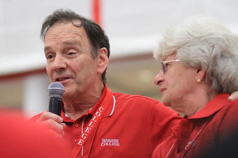 a man in red shirt speaking into a microphone
