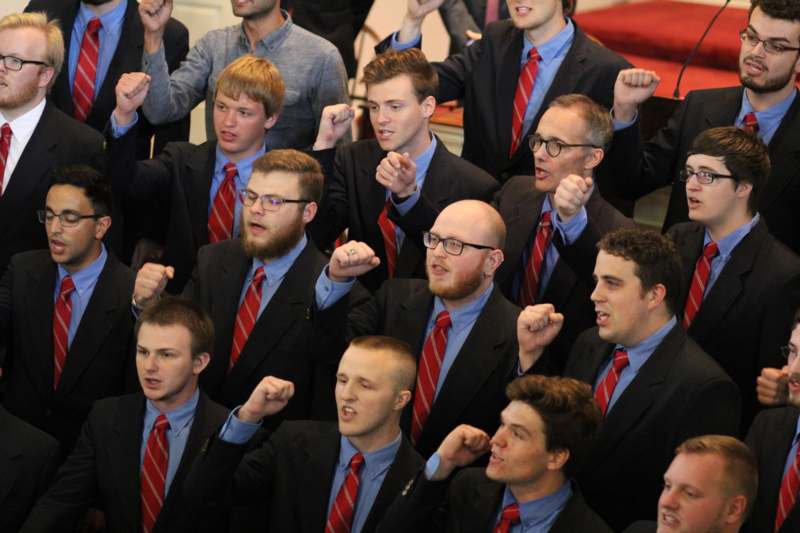 a group of men in suits with their fists raised