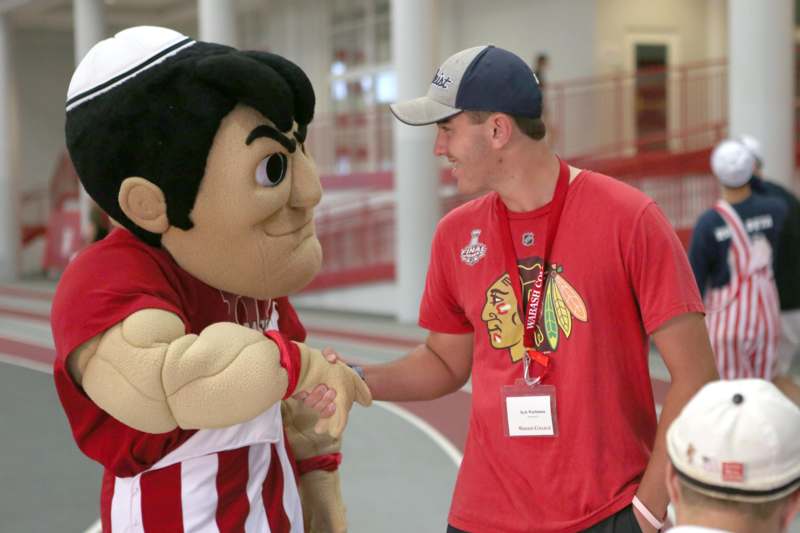 a man shaking hands with a mascot