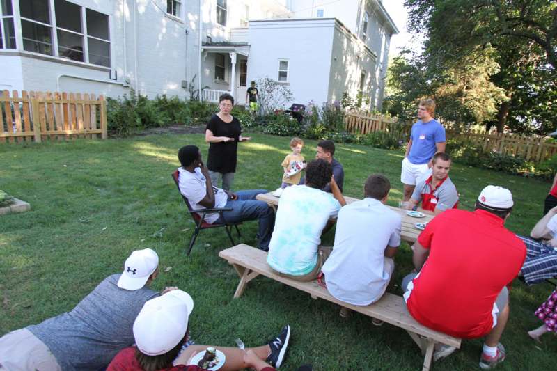 a group of people sitting around a table in a yard