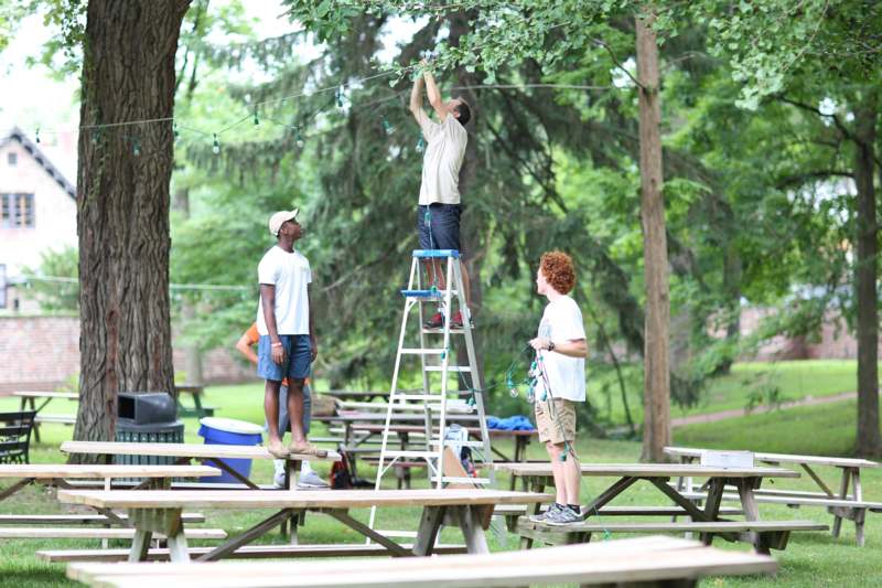a group of people standing on a ladder in a park