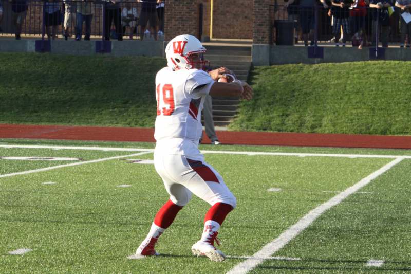 a football player in a uniform throwing a football