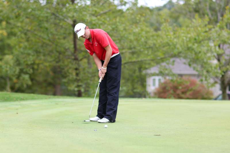 a man playing golf on a green field
