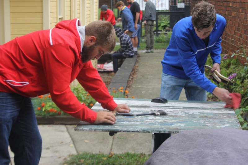 a group of men painting a table