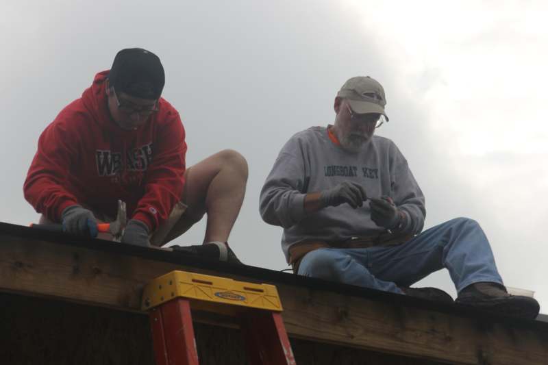 a group of men sitting on a roof