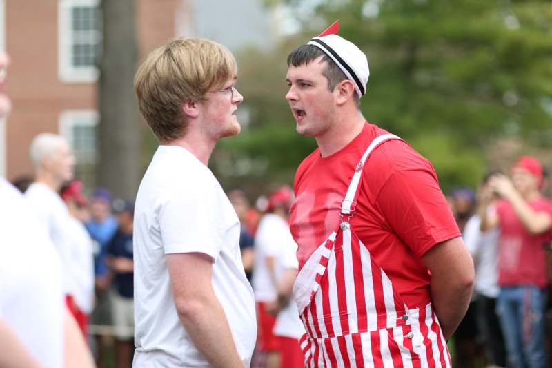 two men in red and white striped overalls talking