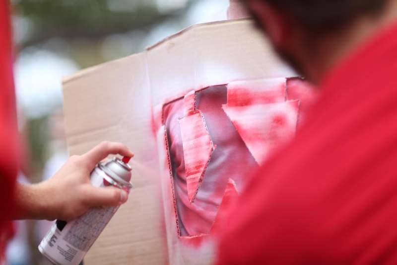 a person spraying a picture on a cardboard