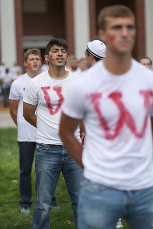 a group of people wearing white shirts with red letters on them