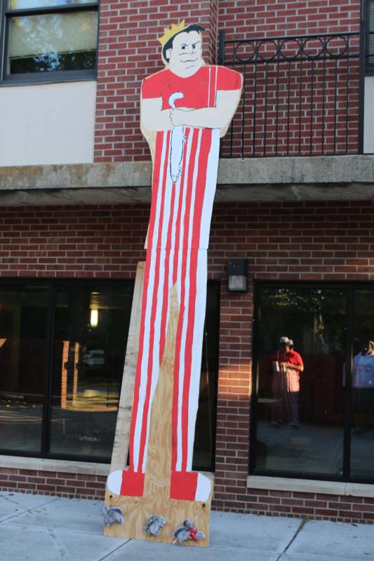 a large cardboard cutout of a man holding a knife and a paintbrush