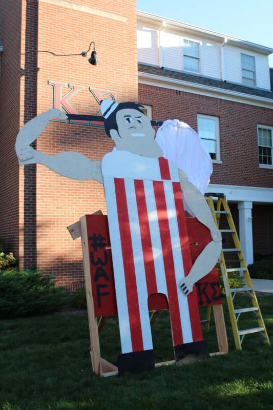 a large wooden cutout of a man flexing his muscles
