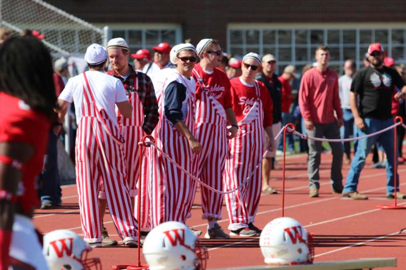 a group of people wearing striped overalls on a track