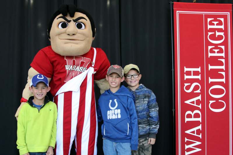 a group of boys posing with a mascot