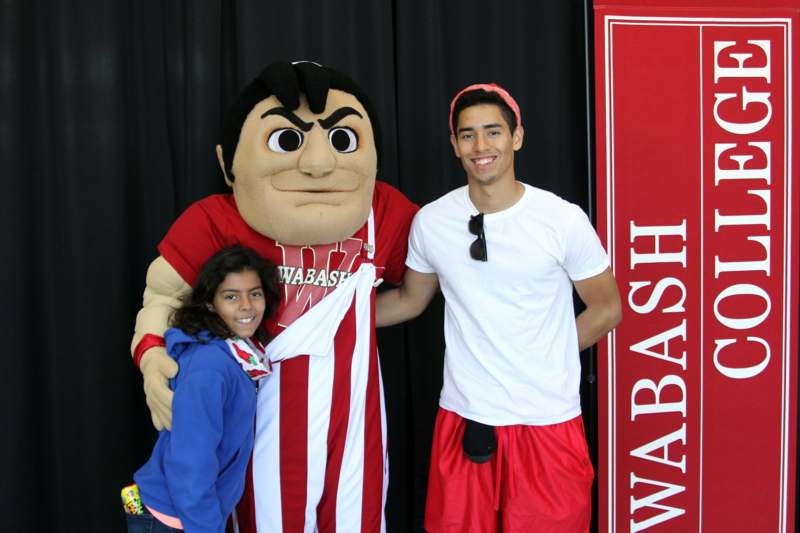 a man and a girl posing with a mascot