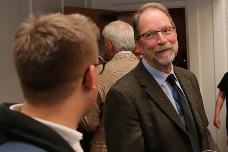 a man in a suit and tie talking to another man