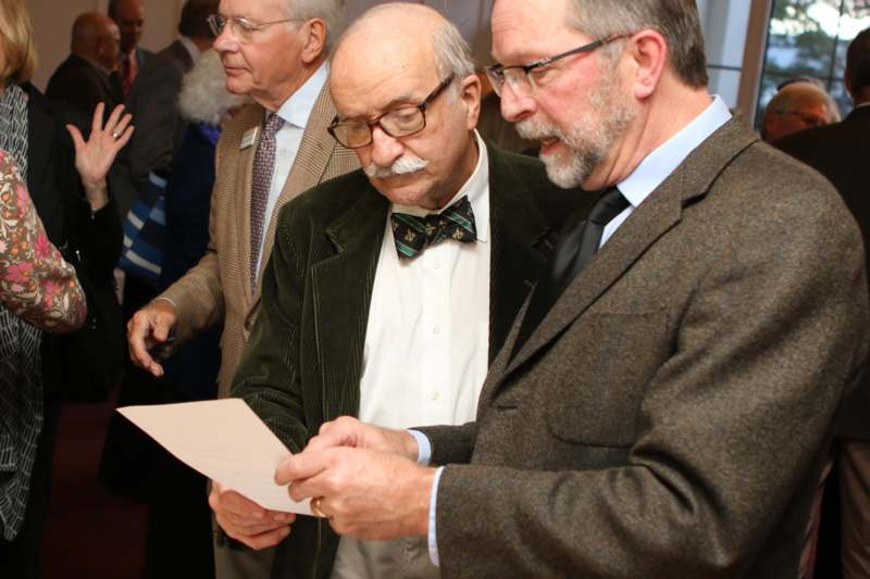 a group of men looking at a piece of paper