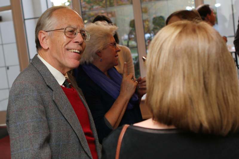 a man in a suit and glasses smiling