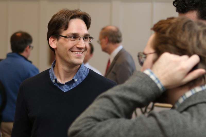 a man wearing glasses smiling