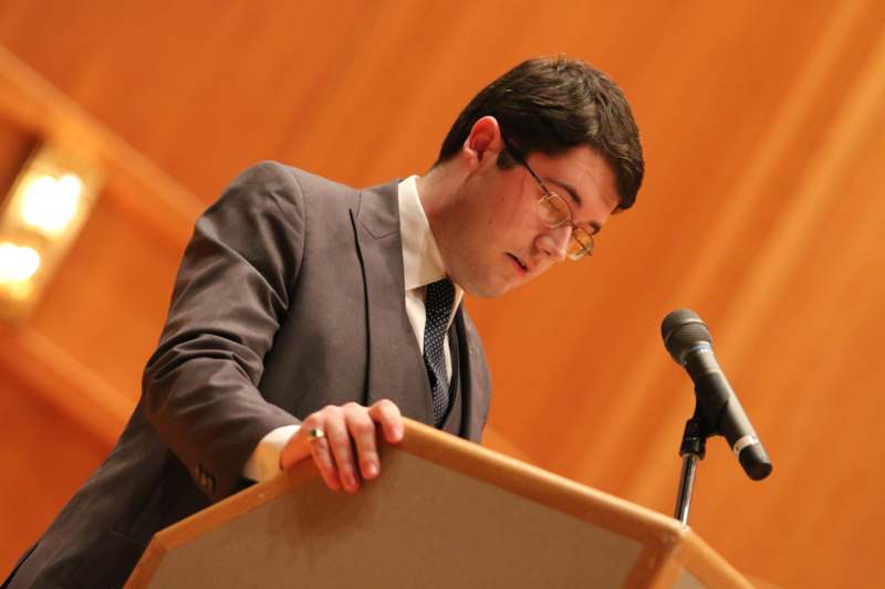 a man standing at a podium with a microphone