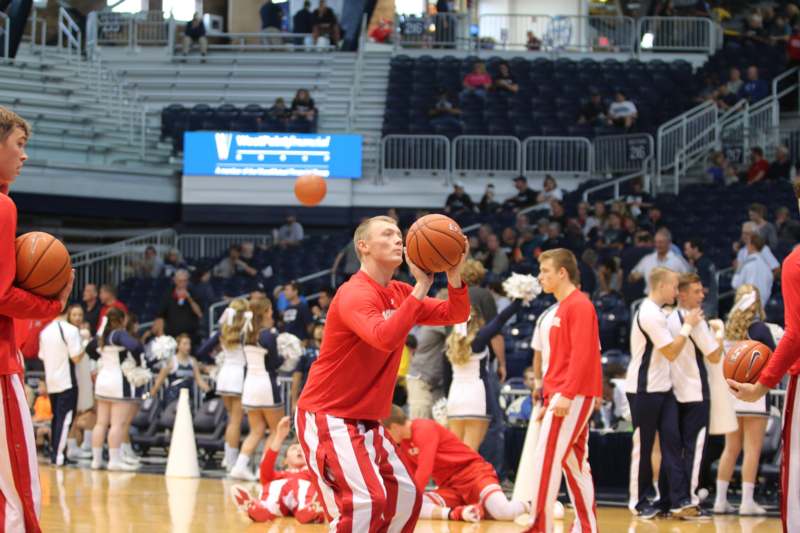 a man in red and white striped pants holding a basketball