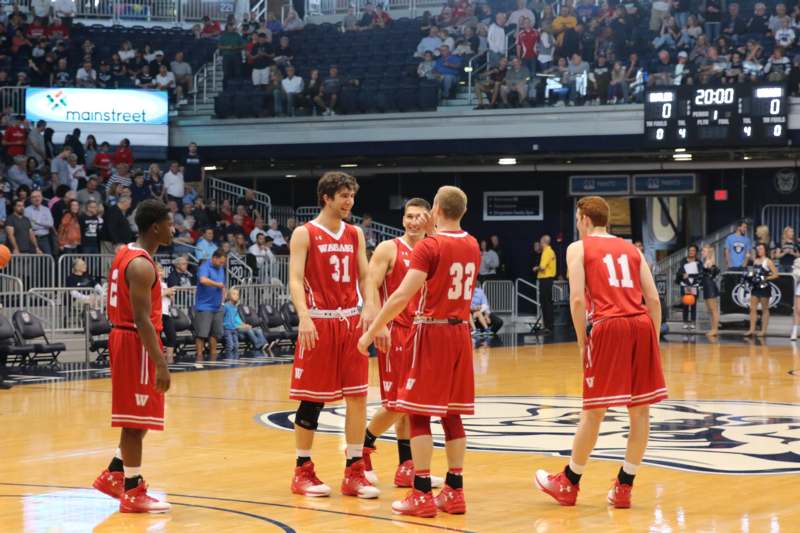 a group of men in red uniforms on a basketball court