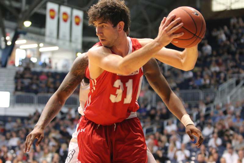 a basketball player in red uniform with a ball in front of him