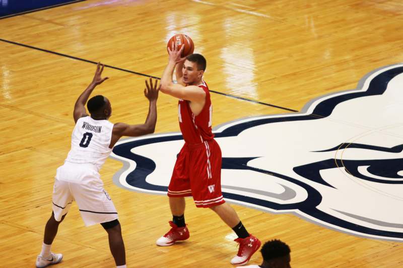 a basketball player in red uniform playing with a basketball
