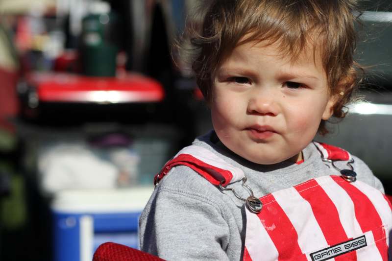 a child in a red and white striped overalls