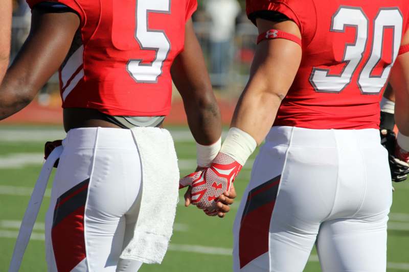 two football players holding hands