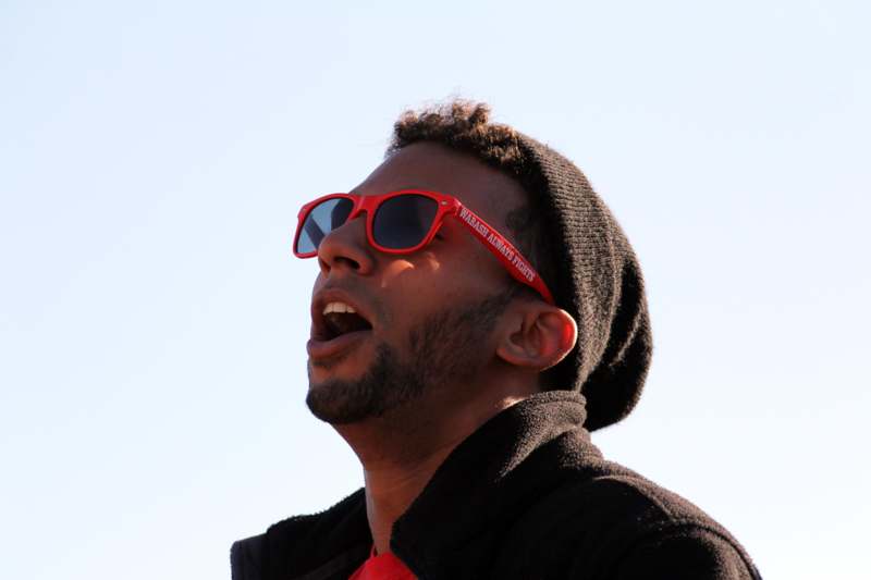 a man wearing red sunglasses and a hat
