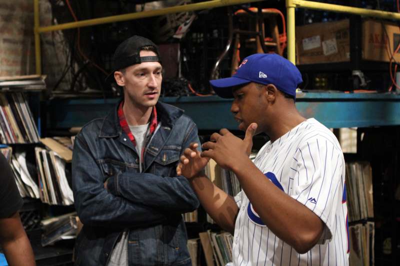 a man in a baseball cap talking to another man