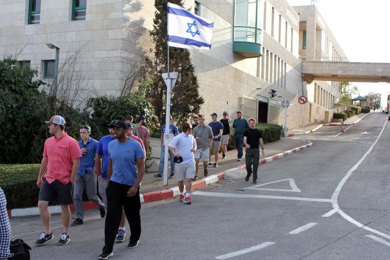a group of people walking down a street with a flag