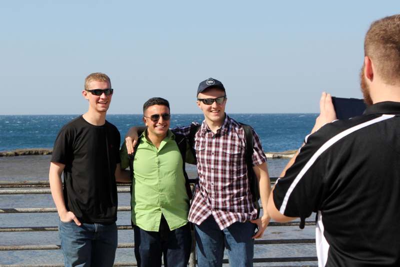 a group of men standing next to a railing