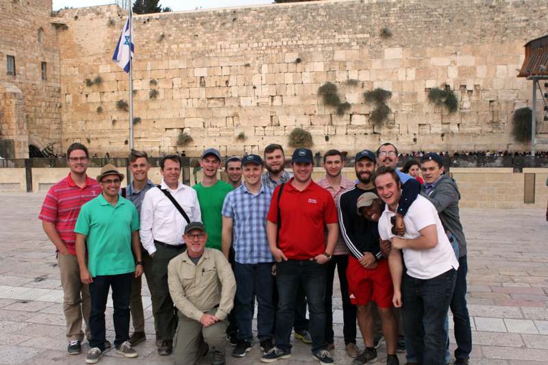 a group of people posing for a photo with Western Wall in the background