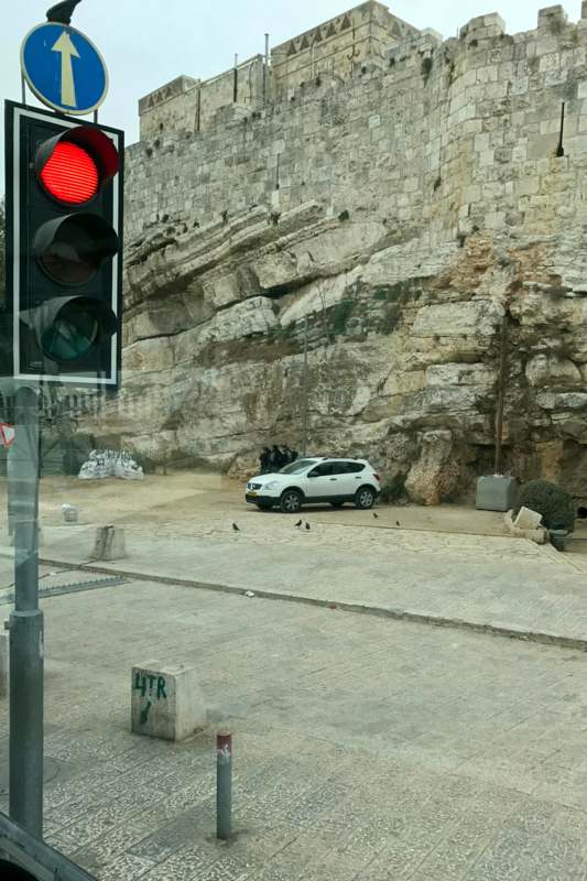 a traffic light next to a stone wall