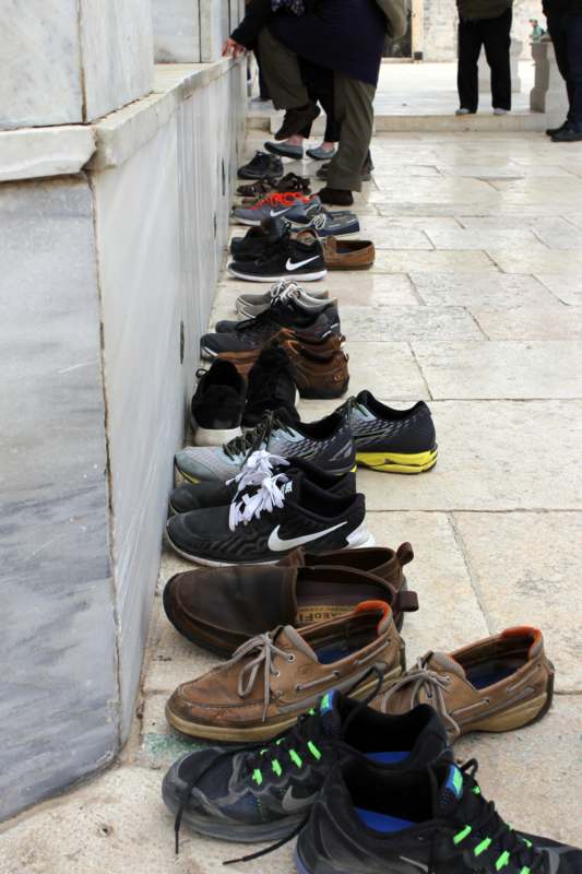 a row of shoes lined up on a sidewalk