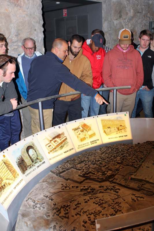 a group of people standing around a model of a city