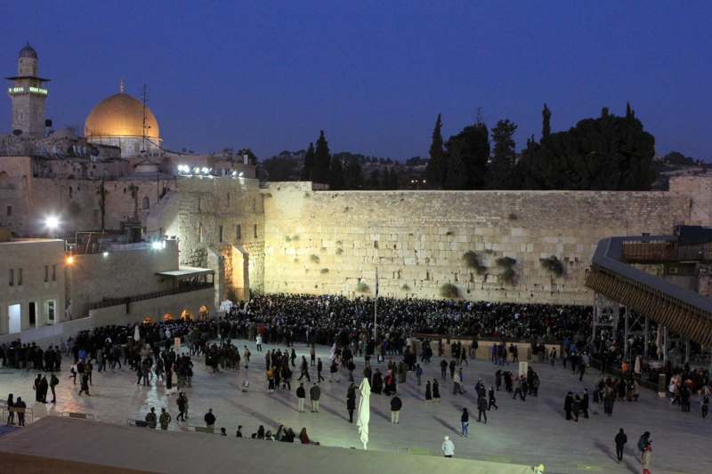 a large crowd of people outside a stone wall with Western Wall in the background