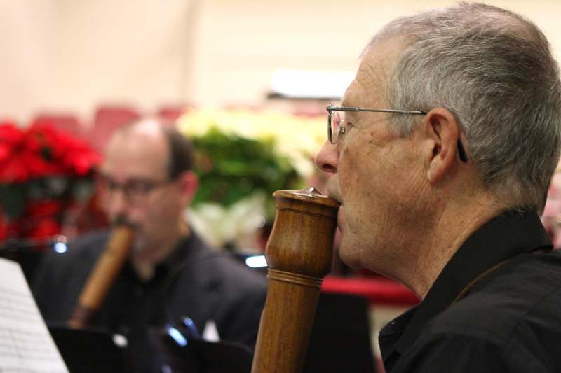 a man in glasses blowing a flute
