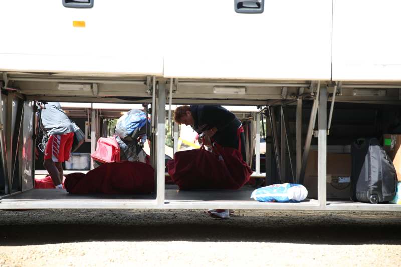 a man sitting under a bus