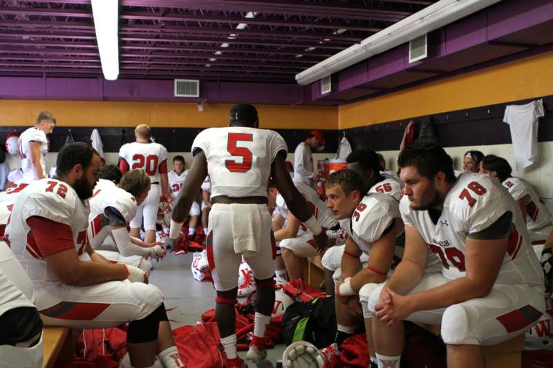 a group of football players in a locker room