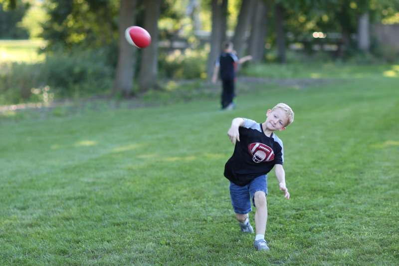 a boy running with a football in the air