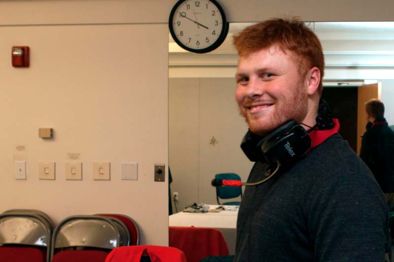 a man with red hair wearing headphones around neck