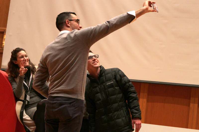 a man taking a selfie with another man