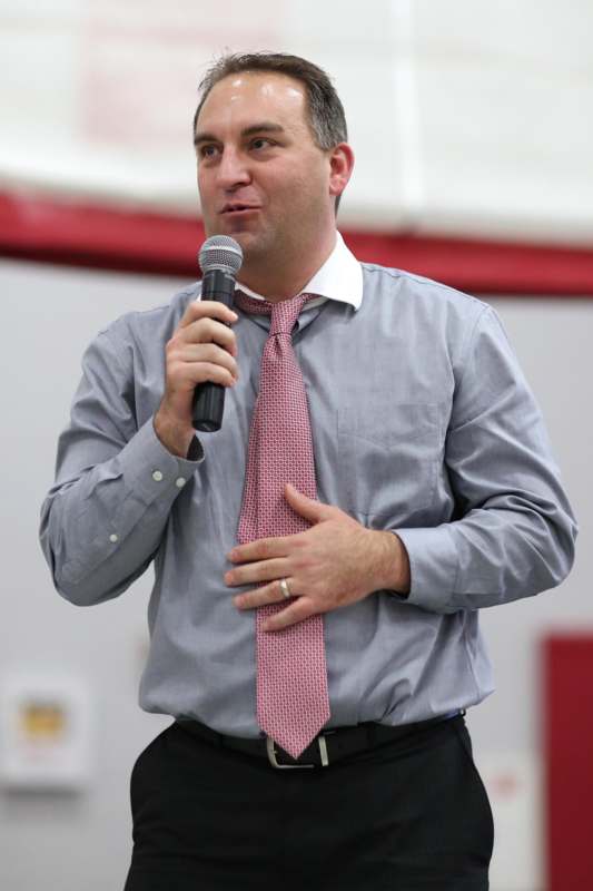 a man wearing a tie and holding a microphone