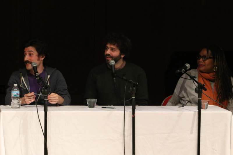 a group of men sitting at a table with microphones