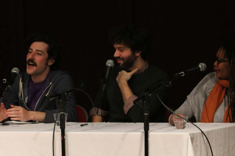 a group of men sitting at a table with microphones
