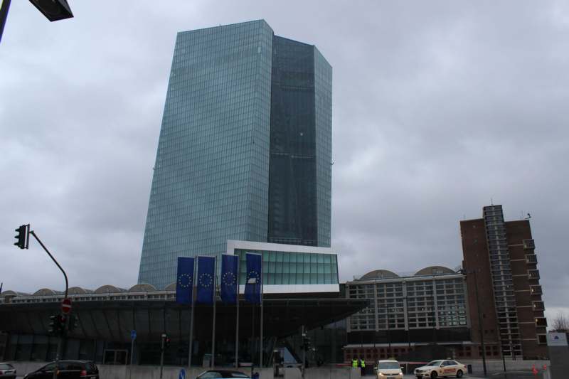 a tall glass building with a few flags