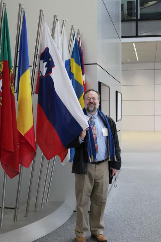 a man standing next to several flags
